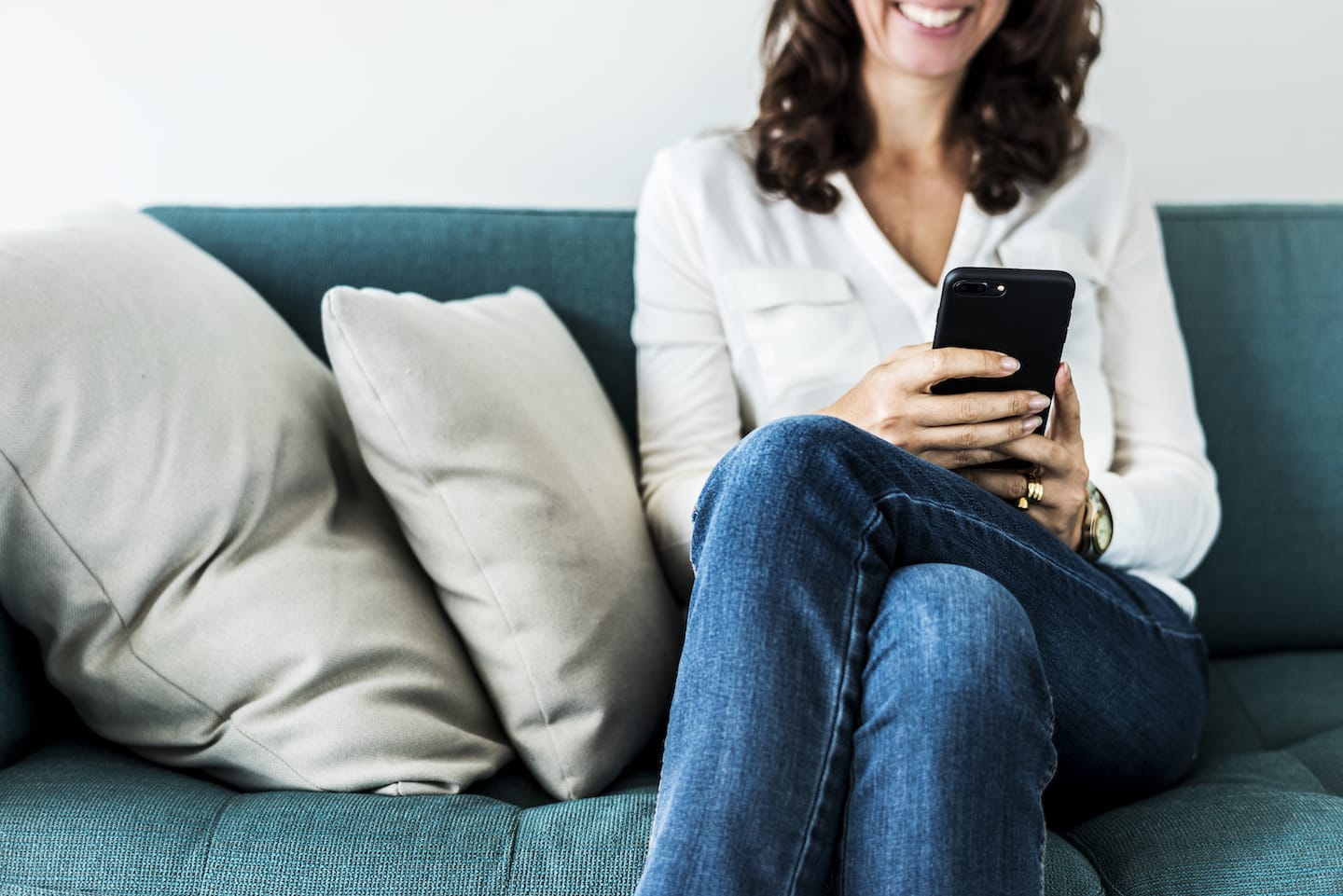 woman-using-mobile-phone-on-the-sofa-P48EVWN