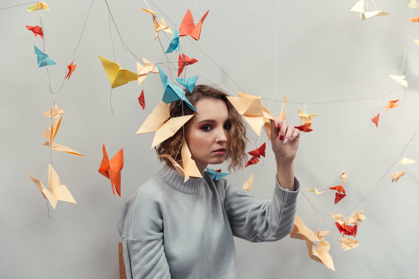 woman standing among colorful origami PZ9GKAU